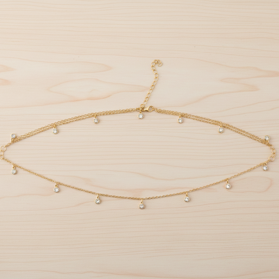 Gold necklace with small beads on a light wood background